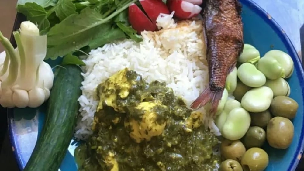 خورش ترش تره شمالی همراه با مخلفاتی مثل زیتون، ماهی شور، سیر و باقالی خام