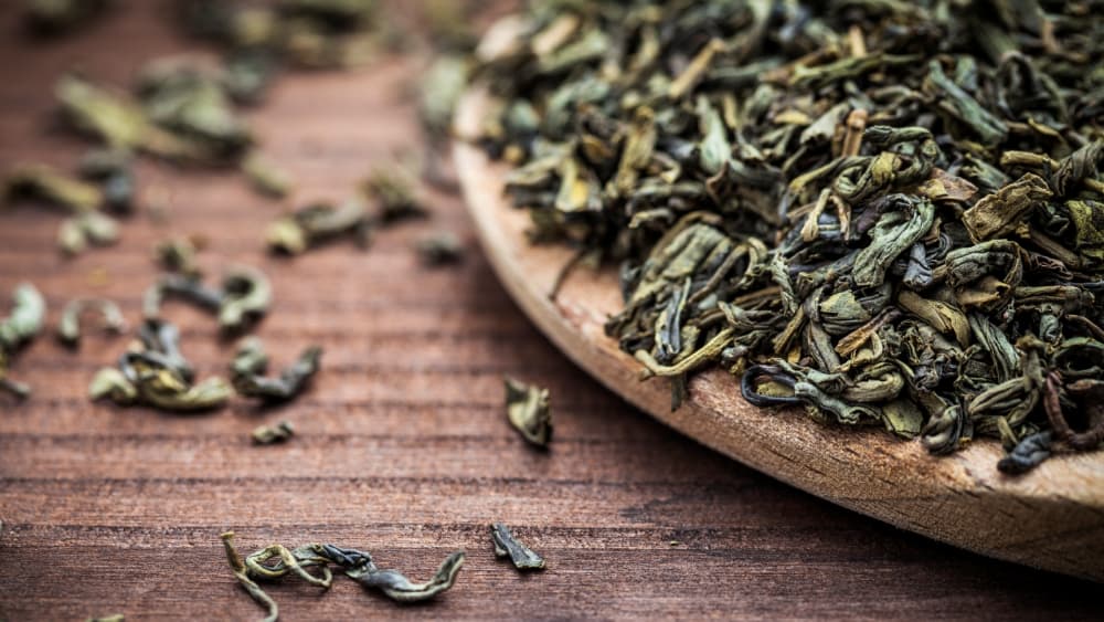 چای سبز خشک روی میز چوبی