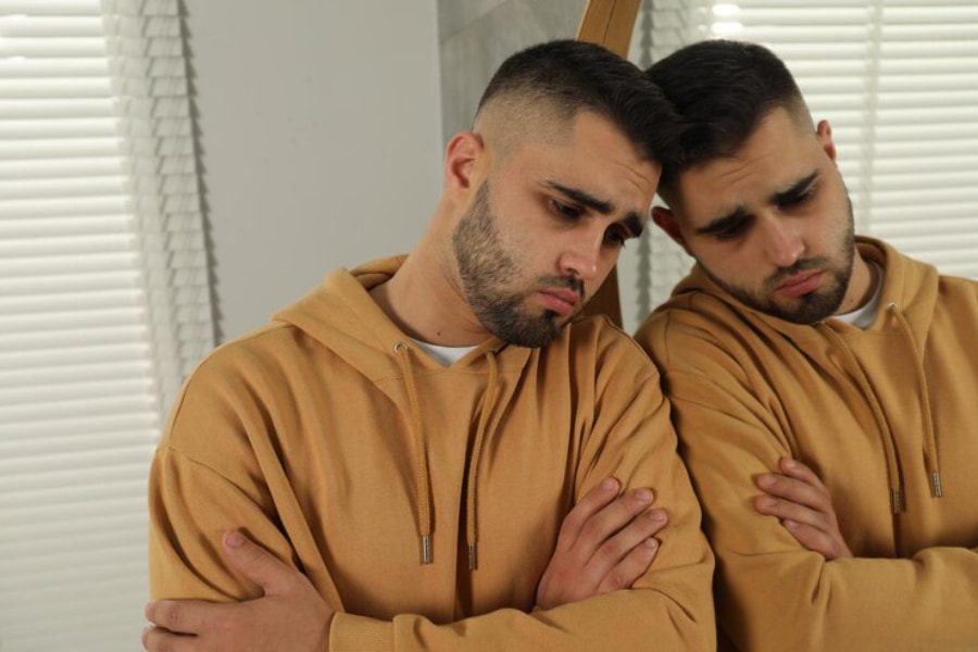 آیا مردان بعد از خیانت پشیمان میشوند؟ مردی جوان و ناراحت نزدیک آینه در خانه