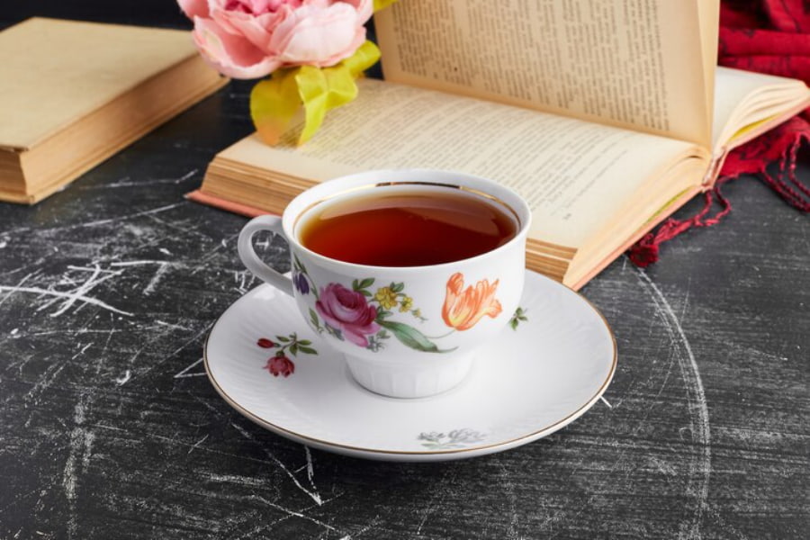 یک فنجان چای ایرانی همراه با کتاب روی میز