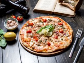 پیتزا تن ماهی با لیمو و چنگال و چاقو روی میز